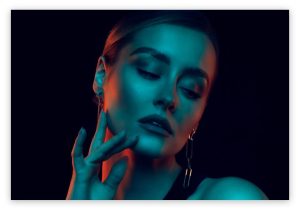brown haiured model in orange and blue dark lighting
