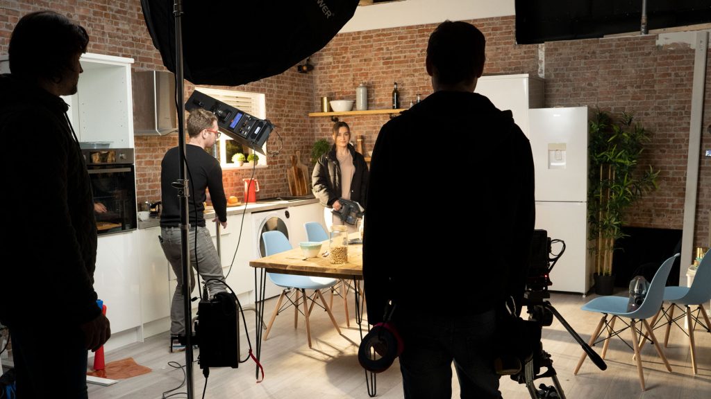 3 male photography team members on a set with a female model