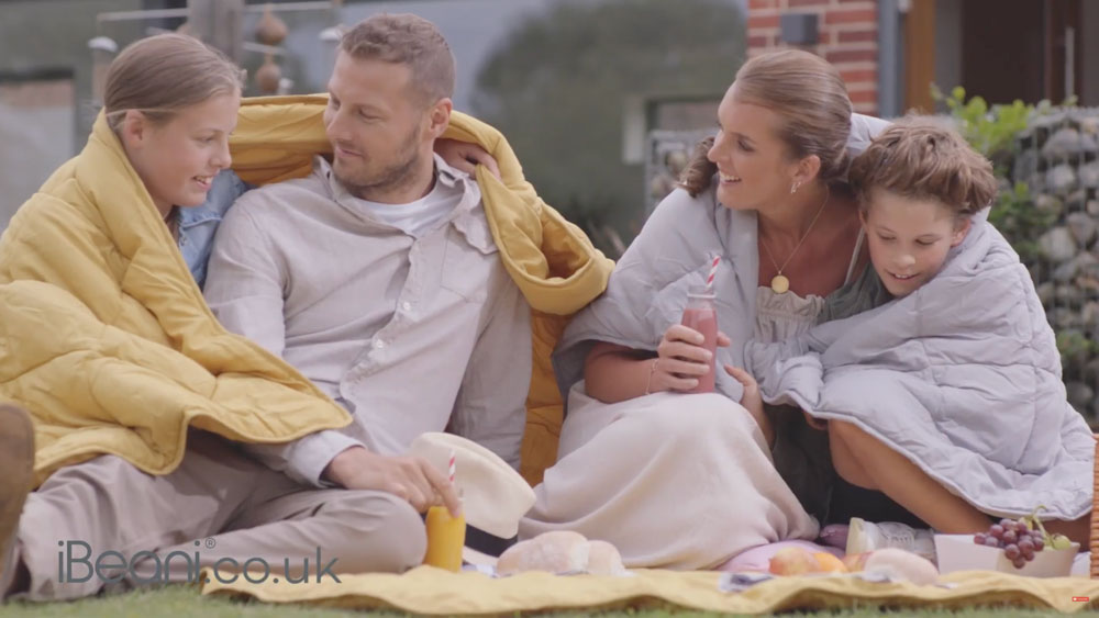 man and woman sitting with two girls